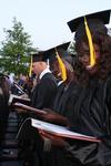Josephine Owino, sports medicine major, and Beatrice Oyenje, physical education & health major, look at their new diplomas at their graduation on Union's Great Lawn. - Photo by Zac Calvert