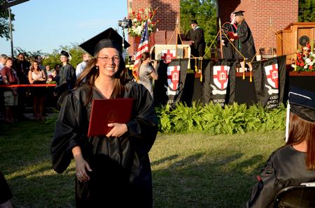 Beth Spain, journalism graduate, walks back to her seat after receiving her degree at spring graduation.