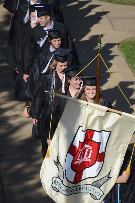 Emily Alm, French and TESL graduate, Brandy Beilke, Spanish graduate, and the rest of the spring graduates follow senior class president Betsy Davis to the Great Lawn. 