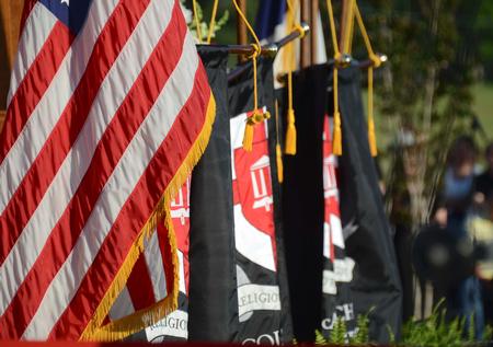 The flag of the United States and Union Banners in front of the stage during spring graduation.