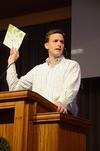 Ben Mandrell, senior pastor of Englewood Baptist Church, references a brochure about GO mission trips during chapel and mentions the importance and blessings of mission work. - Photo by Jacob Moore