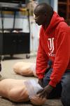 Edwin Kurgat, sophomore business administration major, practices mouth-to-mouth resuscitation in class.  - Photo by Kristi McMurry