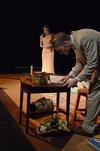 Allison Hearn, sophomore business administration major, looks on anxiously as Ben Haws, junior media communications major, searches records for his father's name during the theater production of "The Importance of Being Earnest." - Photo by Anne Richoux