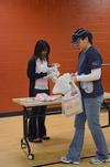 Liane Gozmao, senior biology major, and Haelim Allen, assistant professor of art, unpack bags of supplies for Operation Christmas Child during Campus and Community Day.  - Photo by Anne Richoux