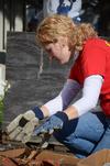Elaura Highfield, senior history major, helps clean rubbish outside of the Bemis Mill Village Museum during Campus and Community Day.  - Photo by Zac Calvert