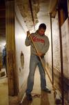 Colton Gebben, sophomore history major, sweeps floors at the Bemis Mill Village Museum during Campus and Community Day. - Photo by Zac Calvert