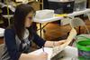 Caitlin Roach, senior history major, helps archive documents and photos at the Bemis Mill Village Museum, during the history department's service project on Campus and Community Day.  - Photo by Zac Calvert