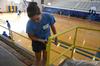 Katie Smith, junior nursing major, paints the railings in the North Side High School gym during Campus and Community Day. - Photo by Ebbie Davis