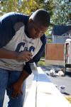 11/1/11 - James Barbee, junior elementary education major, paints a railing at a Jackson home during Campus and Community Day. - Ebbie Davis