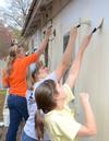 Members of Sophomore Council paint the side of a house during a service project in the Jackson community. - Photo by Jacob Moore