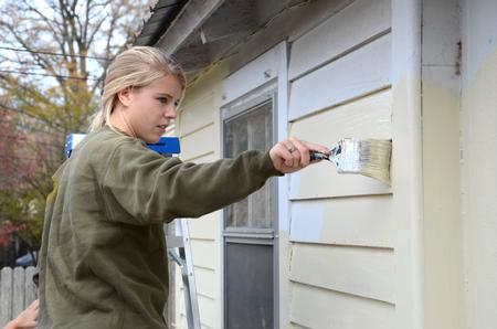 Sophomore Megan Nettle paints the side of a house during a service project with Sophomore Council.