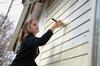 Anne Brewster, sophomore accounting major, paints the side of a house during a service project with Sophomore Council. - Photo by Jacob Moore