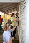 Amiee Brassart, sophomore elementary education major, paints the side of a house with Savannah Hari, sophomore sports medicine major, during a service project with Sophomore Council. - Photo by Jacob Moore