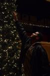 Antoine Hall, senior DMS major, hangs an ornament on a Christmas tree during Deck the Halls, a residence life event to celebrate the holidays. - Photo by Anne Richoux
