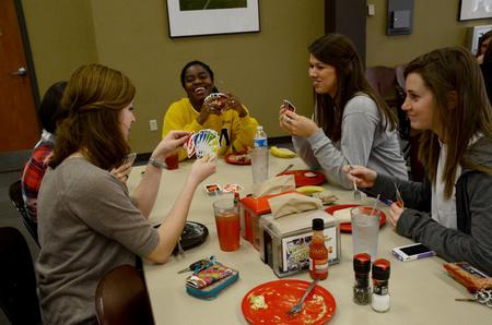 A group of friends laugh together during their weekly game of Uno in the Brewer Dining Hall. 