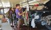 The big red bus stopped at Union University April 3 and offered Union students an opportunity to donate clothes, buy clothes that had been previously donated and interact with Chapman and other representatives from the Red Bus Project. Students could shop for shoes, shirts, or full outfits.   Union Freshman Casey Enzor shops for a shirt in the Big Red Bus. - Photo by Morris Abernathy