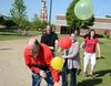 Art department faculty members Lee Benson, Steve Halla, Melinda Posey and Haelim Allen laugh together as they help take down an arch of more than 1,600 balloons that floated over campus. - Photo by Jacob Moore
