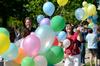 Steve Halla and Haelim Allen, assistant professors of art, help take down an arch of more than 1,600 balloons that floated over campus. - Photo by Jacob Moore