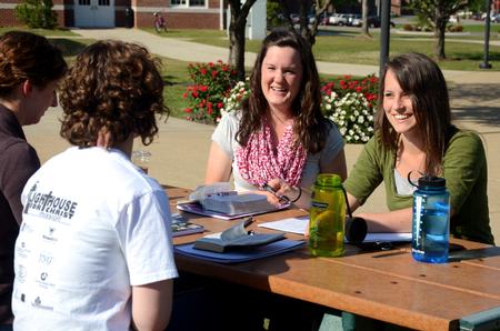 Kate Weise, senior nursing major, Maria Evans, senior TESL major, Rachel Ware, director of discipleship, and Courtney Allen, senior social work major, chat and laugh together on a beautiful Spring day.