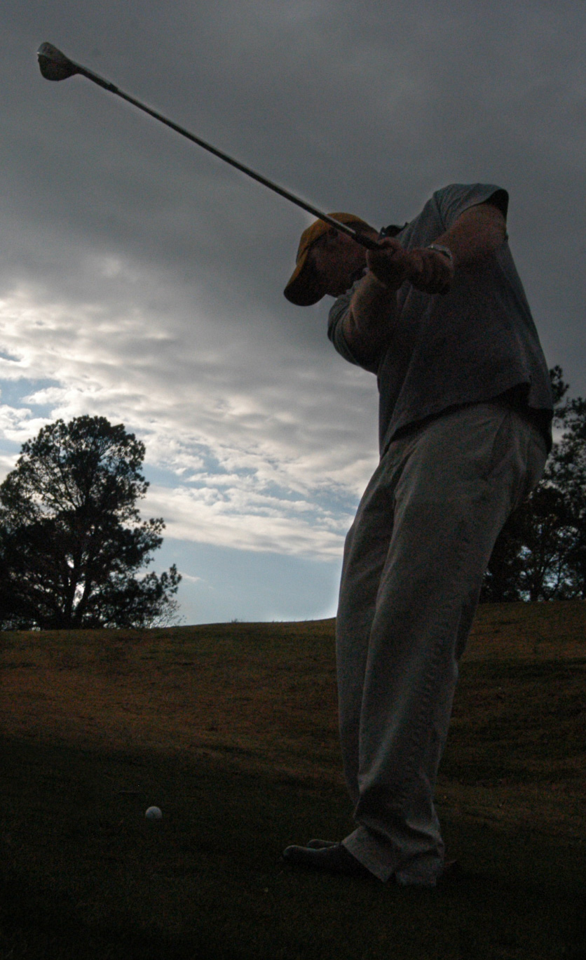 03/30/04 - Freshman golfer Chase Whitby drives a ball on a cloudy day.