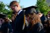 5/19/12 - Luke Allison and Jessica Attig, mathematics graduates, bow their heads during the opening prayer at spring graduation.  - Ebbie Davis