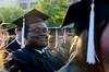 Nigel Manuel, media communications graduate, grins for a photo during spring graduation.  - Photo by Ebbie Davis