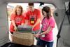 Focus leaders, Megan Coley, senior elementary education major, and Tucker Watson, senior Christian studies major, assist Anna Goodman, freshman journalism major, as she unpacks her car during new student move-in day.   - Photo by Ebbie Davis