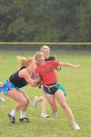Elizabeth Cochran, senior sport management major, runs with the football as Anna Coley, sophomore elementary education major, tries to pull her flags in an intramural game during Family Weekend. - Photo by Zac Calvert