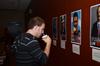 Jonathan Rogers, junior applied linguistics major, drinks coffee while reading posters that are part of MOSAIC Unity show. - Photo by Zac Calvert