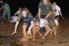 Juniors Lindsay Grace Brown, learning foundations major, Nathan Hooper, Christian studies major, and Carol Lee Weaver, learning foundations major, enjoy a game of leap frog in the mud during Midnight Mudness. The event was sponsored by the Young Alums last Thursday. - Photo by Jonathan Blair