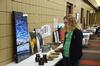 Melody Kramer, sophomore nursing major, looks at different student art on sale in the Student Union Building during the annual pottery sale. - Photo by Zac Calvert