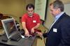 Willie George, PC support specialist, and Jim Avery, associate vice president for information technology, set up for a presentation to faculty members at the start of the Fall semester.  - Photo by Morris Abernathy