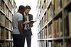Jason Crawford, assistant professor of English, helps a student choose a book in the library.  - Photo by Kristi McMurry