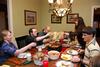 Betsy Pingen, adjunct for the department of language, serves dinner to Grace Morriss, Ryan Harris, and Ward Howard who visited their home as a part of SAC's Be Our Guest. - Photo by Anne Richoux
