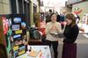 Yumi Miyazaki, junior political science major, shows a keepsake book from Japan to Emily Harper, international student advisor, during the CultureFEST culture fair. - Photo by Jacob Moore