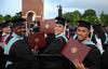 Deonte Singfield, Joshua Shelley and Preston Scott, master of urban education graduates, hold up their newly received diplomas at Spring Graduation. - Photo by Jacob Moore