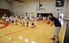 Trevor Lydic, assistant men's basketball coach, coaches children on dribbling during the athletic department's basketball Pee Wee Camp in the Fred DeLay Gymnasium. - Photo by Jacob Moore