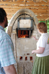 Art professor Lee Benson and junior Zandy Jackson monitor the fire on the homemade wood kiln built by six university students on the back of Union’s property near Facilities Management. - Photo by Lindsay Stavish