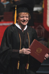Provost administrative assistant Linda Baker flashes a big smile after receiving her degree at fall graduation. - Photo by Jim Veneman