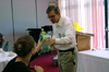 David Ward, professor of physics, demonstrates an experiment on air pressure to fellow educators at the science fair luncheon and organizational meeting. - Photo by Amanda Herron