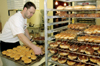Owner Jody Evans frosts glazed doughnuts preparing for the morning rush at the new local doughnut shop DoDahs. - Photo by Lindsay Stavish