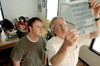 Junior Brad Moore, digital media studies major, examines negatives with Jim Veneman, instructor of photojournalism in the photo house, while senior Ashley Mitchel looks on. - Photo by Kristen Nicole Sayres