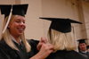 Public relations graduate Jill Martin assists fellow public relations graduate Amanda Jones prior to the spring graduation ceremony. - Photo by Kristen Nicole Sayres
