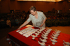 Nursing professor Melanie Matthews helps distribute the white New Testaments and the lamps during the nursing dedication service. - Photo by Morris Abernathy