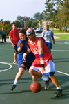 Men's Basketball Head Coach Ralph Turner drives to the basket against student Tina Smith in the Faculty/Staff vs. Student game at the dedication of the Class of 2002 Basketball Court. - Photo by Justin Veneman