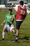 Intramural Soccer Action - Tyler McMurtry (green) winces as Chris Clermont (33) clears the ball. - Photo by Jonathan Blair