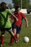 Intramural Soccer Action - Chi Omega Mary Ellen Vaughn tries to pass her Sniper opponent. - Photo by Jonathan Blair