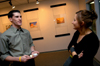 Lisa Whiffen talks with Senior DMS major Adam Houston during his senior graphic design show in the art gallery. - Photo by Jonathan Blair