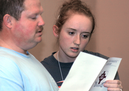 Gary Stephens and Alyssa Jones look over their program during the New Student Orientation Chapel.