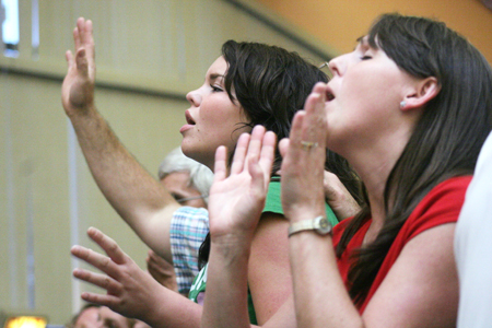 Tiffany Fredericks (left) and her mother Cindi (right) of Delmar, N.Y. participate in the worship service during New Student Orientation.
